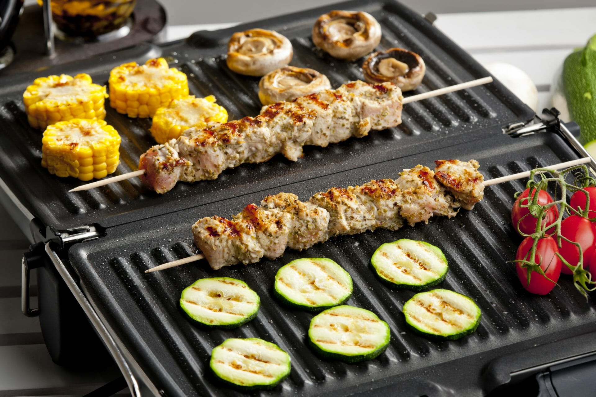 electric grill with meat and vegetables on it